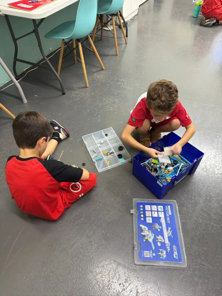 Alunos selecionando peças do próprio kit durante a aula