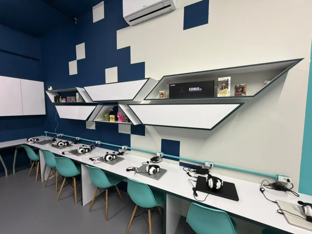 Bancada com notebooks individuais e nichos de projetos dos alunos