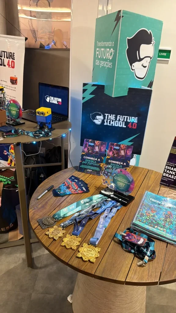 Estande da The Future School 4.0 com as medalhas e o selo da OBT 2026