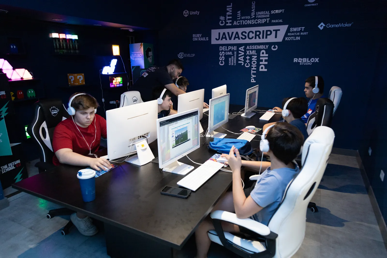 Turma da The Future School em aula de criação de games, cada aluno em uma estação própria